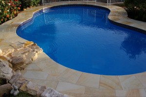 Teakwood sandstone pool paving and matching pool coping