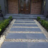 Bluestone steppers in a front yard forming a pathway.