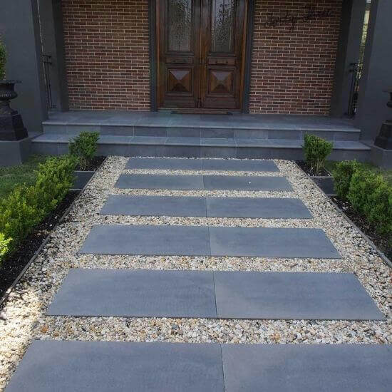 Bluestone steppers in a front yard forming a pathway.